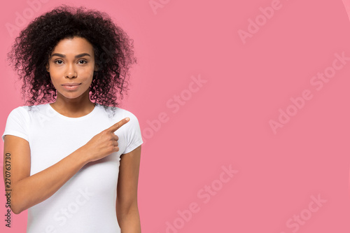 Serious confident african woman looking at camera pointing finger aside