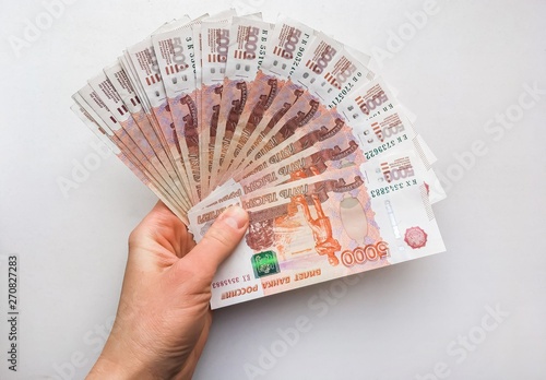 Hand with Russian rubles on a white background, bills five thousand rubles, money fan in hand