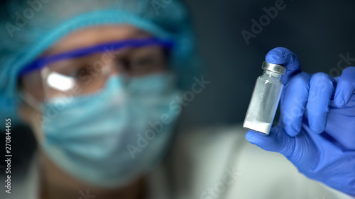Scientist holding ampule with white powder, illegal pharmacy production, drugs