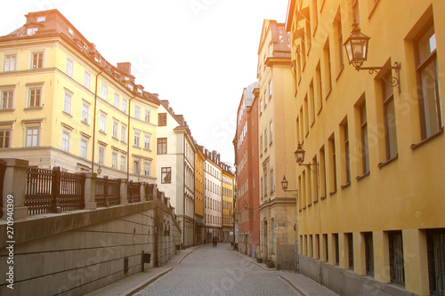 Deserted pedestrian street in the old part of Stockholm, Sweden. Colorful houses with vintage lanterns.