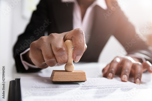 Businesswoman Putting Stamp On Documents