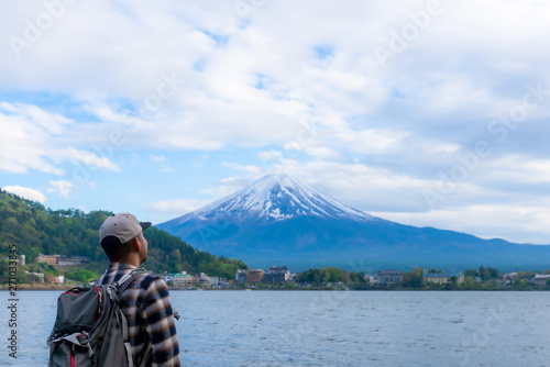 Young Boy Backpackers traveling Beautiful Fuji Mountain, Men Backpacking Fujisan volcano at Kawaguchiko lake, Japan.