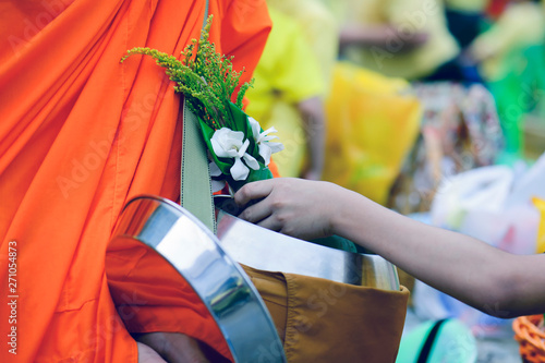 Buddhists bring food and flowers to monks to make merit for monks according to Buddhist beliefs.