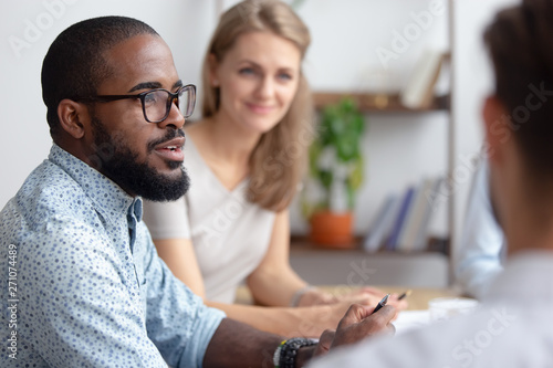 Male african-american talking to coworkers timeout in office