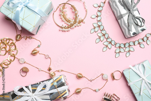 Beautiful jewelry and gift boxes on color background, flat lay. Space for text