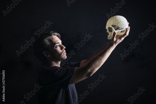 Actor con calavera interpretando la obra de teatro Hamlet de Shakespeare