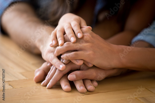 Close up of loving family stack hands showing unity