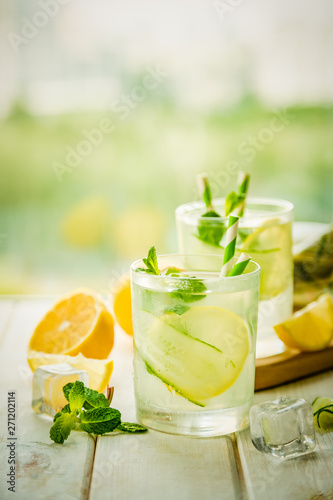 Summer lemonade in glasses in front of window, copy space