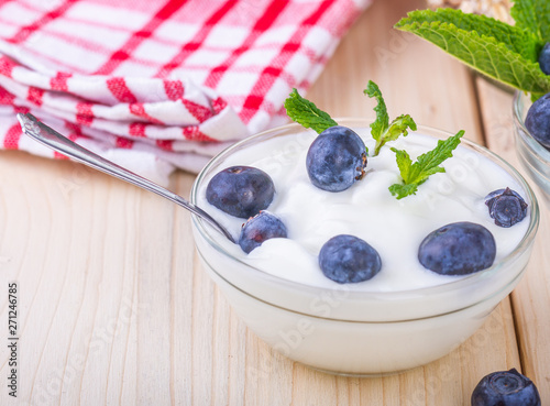  Jogurt z jagodami. Czarne jagody w misce podane na sniadanie. Musli z owocami, swieze owoce. Zdrowe i pozywne sniadanie.