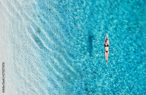 Aerial view of a girl on ocean on Bali, Indonesia. Vacation and adventure. Turquoise water. Top view from drone at ocean, azure watre and relax girl. Travel and relax - image