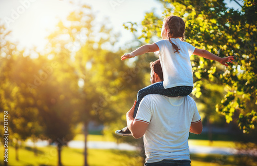 concept of father's day! happy family dad and child daughter back in nature