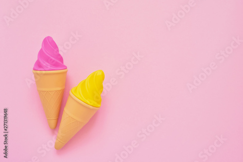 Pink and yellow toy ice-cream on pink background. Minimalism, summer concept.