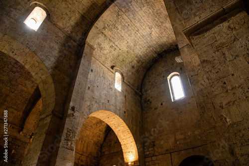 Interior of an old cathedral / church in Europe. Arches, vaulted ceilings and walls lit by lamps