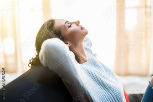 Closeup of a smiling young woman lying on couch at home