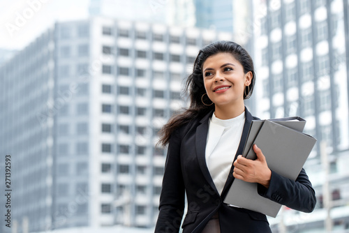 Young beautiful Latino businesswoman standing outdoors