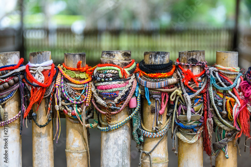 Colourful bracelets left by visitors at the site of a mass grave, Choeung Ek Killing Fields Genocide Centre, Phnom Penh, Cambodia