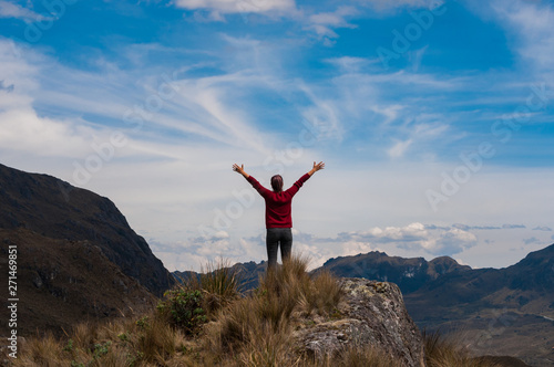 Mujer en la cima de una montaña, con brazos elevados de positiva