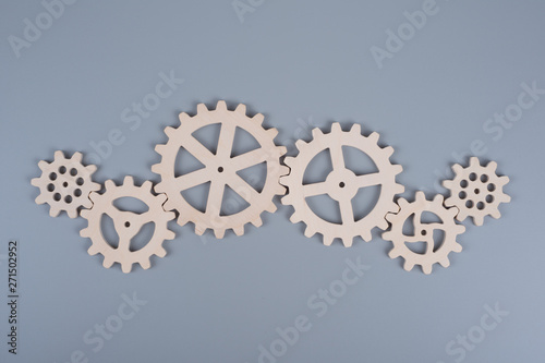 Gears assembled in a puzzle mechanism to work on a gray background. Business concept idea, partnership, cooperation, teamwork.