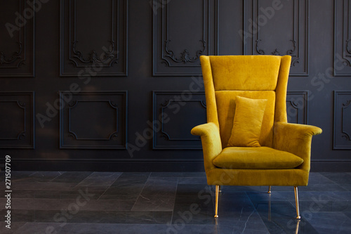 Stylish bright yellow chair against a dark gray wall