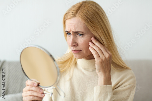 Anti-Wrinkle Skin Care. Sad Woman Looking In Mirror