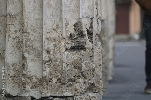 Background Damaged columns of a historic building on the sidewalk in the city