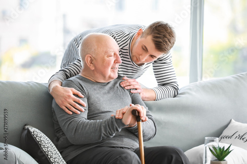 Male caregiver with senior man in nursing home