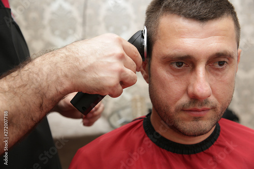Close-up. Professional hairdresser cuts the hair to the client using a trimmer. Salon care. Concept for hairdressers and barbershop.