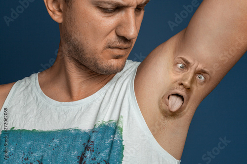 Smelly armpits in men. Concept of twisted panting face from bad smell.