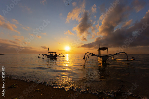 Travel in the morning sunrise in Bali, Indonesia. Traditional fishing boats at Sanur beach, Bali, Indonesia.