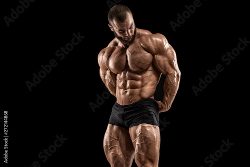 Bodybuilder man isolated on the black background. Strong male naked torso abs
