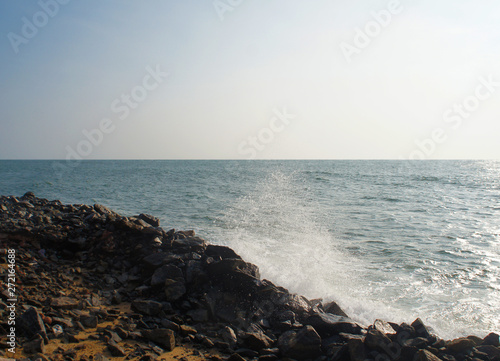 Waves seethe and hit the stone beach on the tropical island of Sri Lanka in the summer.