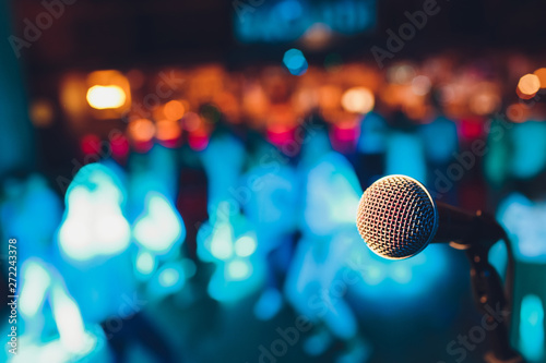 microphone on a stand up comedy stage with colorful bokeh , high contrast image.