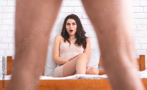 Woman in disbelief looking what's between man's legs