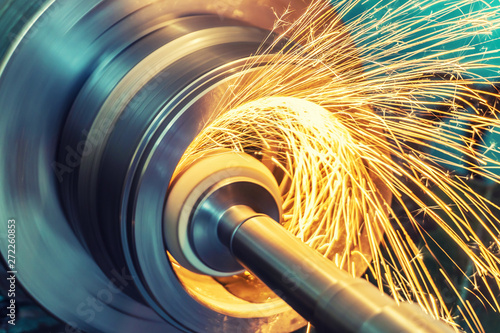 Internal grinding of a cylindrical part with an abrasive wheel on a machine, sparks fly in different directions. Metal machining.