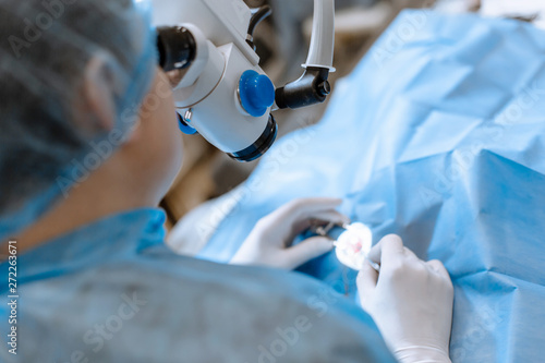 A professional ophthalmologist performs eye surgery with a microscope. The doctor inserted the dilator into the eye, washes and removes pus with a syringe. Endoscopic eye surgery. medical equipment