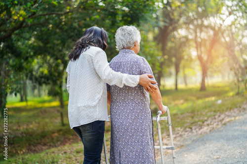 Help and care Asian senior or elderly old lady woman use walker with strong health while walking at park in happy fresh holiday. 