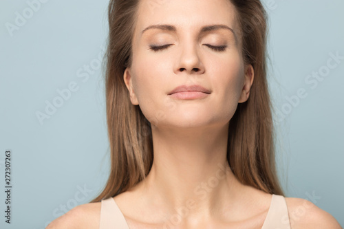 Close up young woman with closed eyes relaxing and breathing.