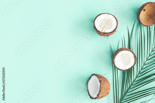 Summer composition. Coconut, palm leaf on mint background. Summer concept. Flat lay, top view, copy space