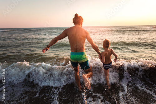 Father and son playing on the beach at the day time