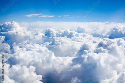 White clouds on blue sky background close up, cumulus clouds high in azure skies, beautiful aerial cloudscape view from above, sunny heaven landscape, bright cloudy sky view from airplane, copy space