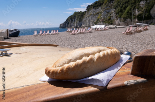 Cornish pasty on boat , beach location in West Country in summer with deck chairs and fishing boat