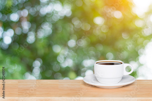 Empty wood table top and coffee cup blur nature background with copy space for display or montage your products