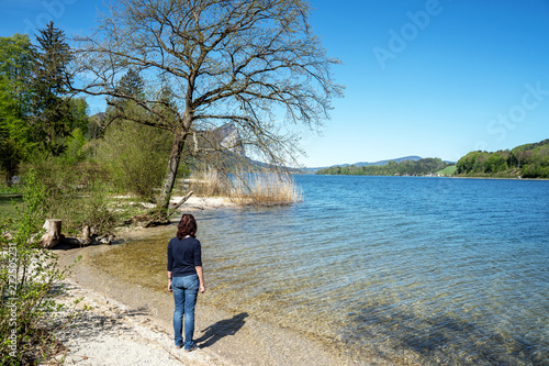 Junge Frau steht an einem See in Österreich