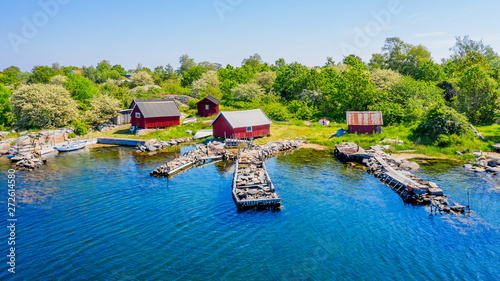 Stone filled jetties and fishing sheds seen from the sea. Location Hasslo island in Blekinge archipelago, Sweden.