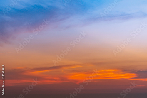 Dramatic blue and orange sky and clouds abstract background. Red-orange clouds on sunset sky. Warm weather background. Art picture of sky at dusk. Sunset abstract background. Dusk and dawn concept