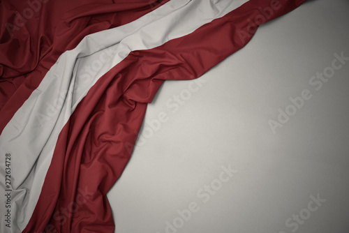 waving national flag of latvia on a gray background.