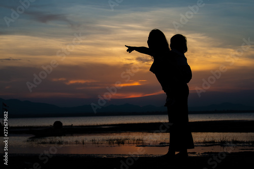 Silhouette of mother and daughter on sunset,Thailand people,Happy family concept
