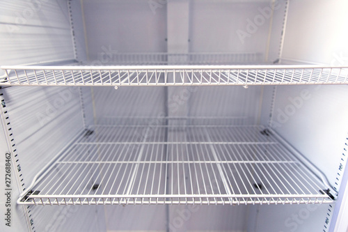 Open home refrigerator with empty shelves