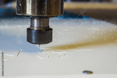 CNC cutter machine in action, cuting off plastic material