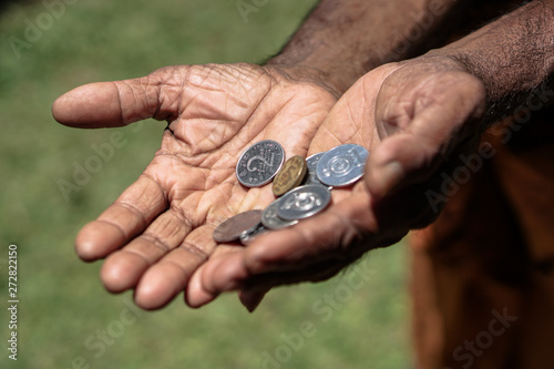 Coins in dark working hands. Beyond the poverty line in Asian countries. Subject soap bar.